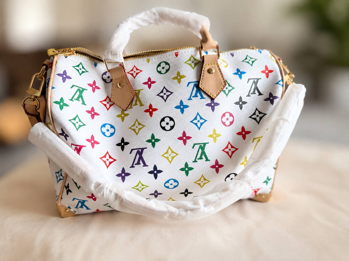 white luxury-style handbag with a colorful monogram pattern,